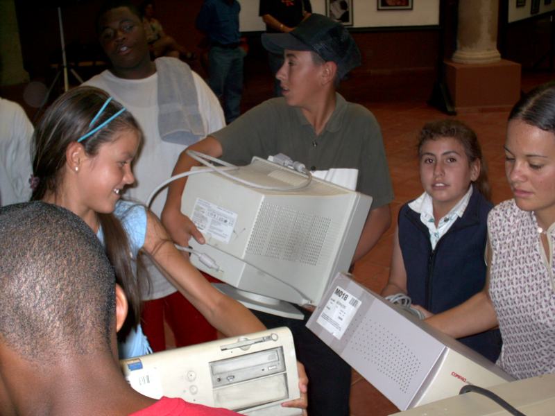 Chicago and Durango teenagers passing rebuilt computer monitors and towers hand to hand in a tiled hall