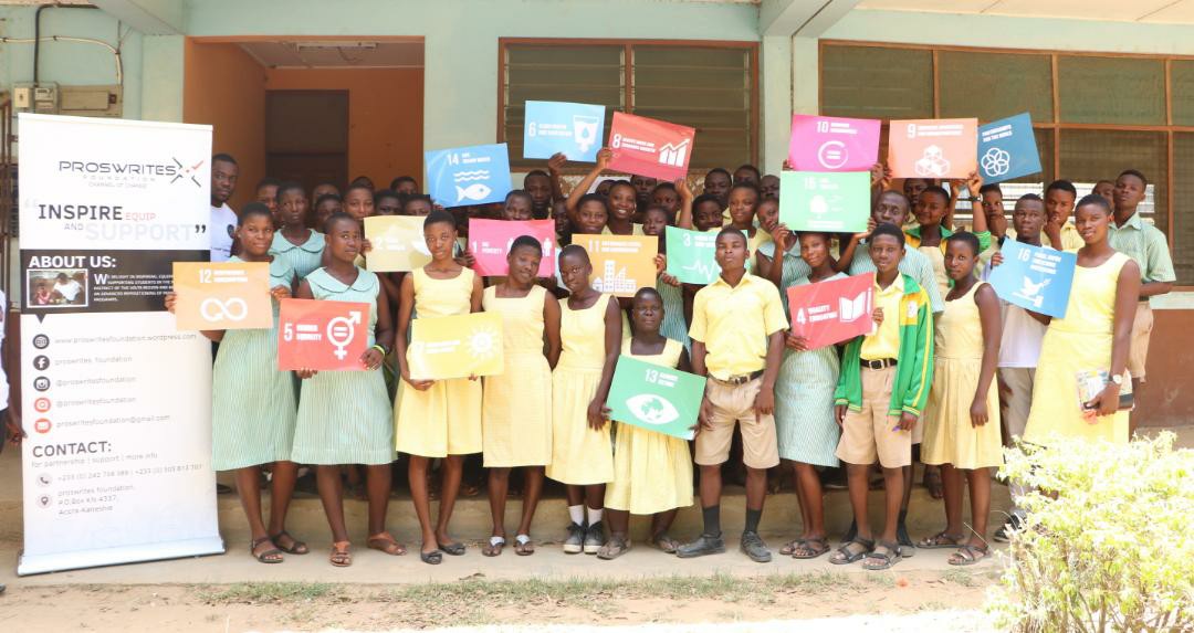 Young people at a Proswrites Foundation gathering in Ghana holding sustainable development goal cards